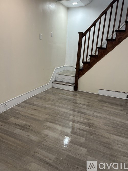 A wooden staircase with a white wall and wooden flooring.