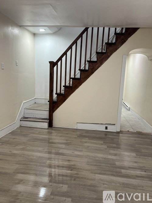 A staircase with a wooden handrail and white steps.