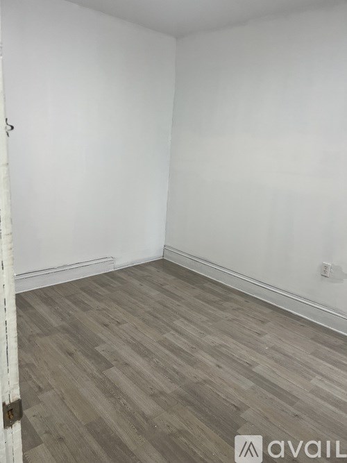 A room with wooden flooring and white walls.