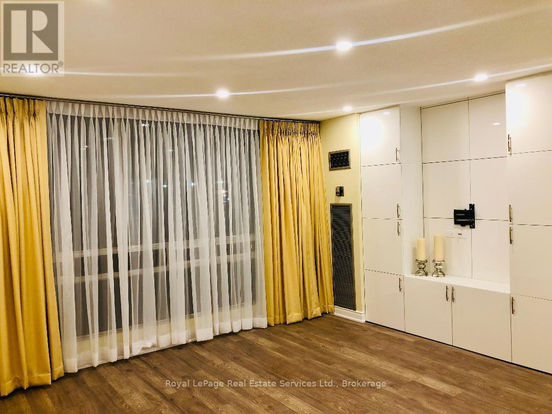 A room with a white ceiling, wooden floor, and a yellow curtain.