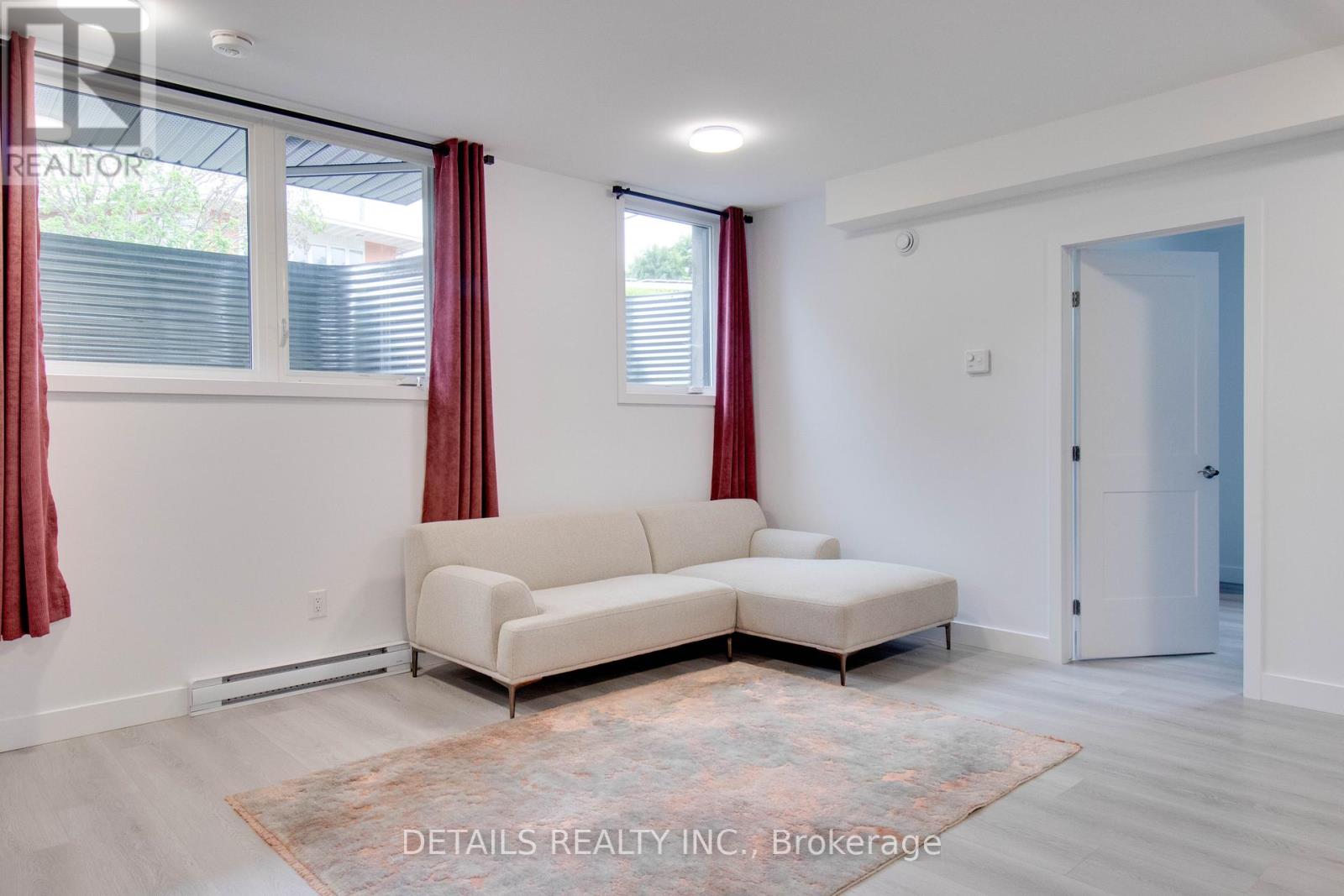A living room with a white couch and a rug.