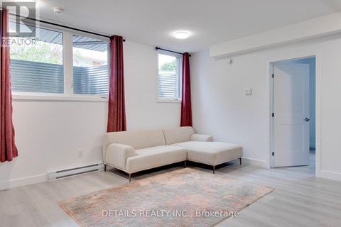 A living room with a white couch and a rug.