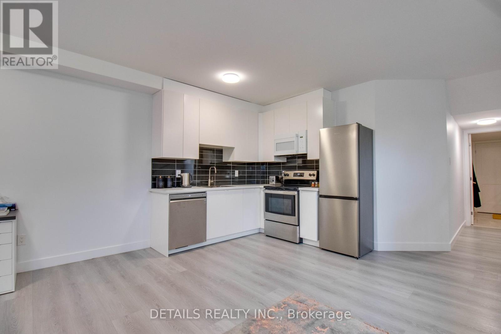 A modern kitchen with stainless steel appliances and white cabinetry.