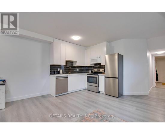 A modern kitchen with stainless steel appliances and white cabinetry.