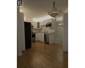 A kitchen with wooden floors and white walls.