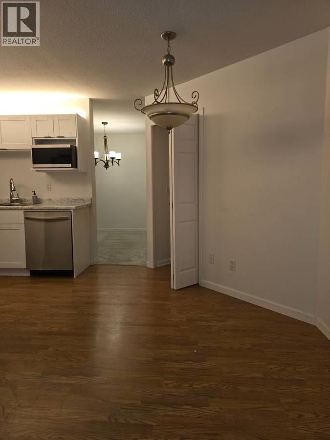 A well lit kitchen with a wooden floor.