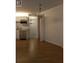 A well lit kitchen with a wooden floor.