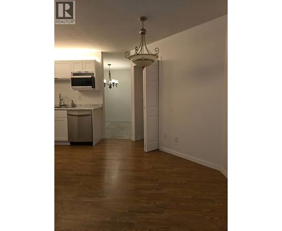 A well lit kitchen with a wooden floor.