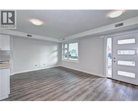 A spacious room with wooden flooring and a sliding door leading to a balcony.