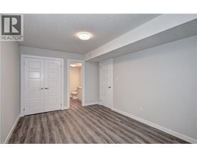 A bedroom with a white door and a grey floor.