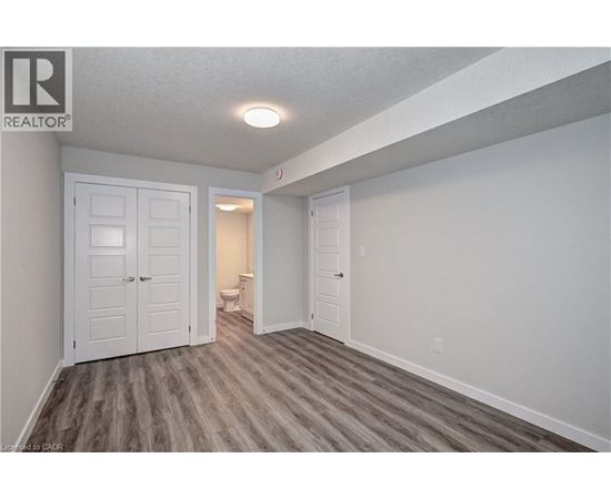A bedroom with a white door and a grey floor.