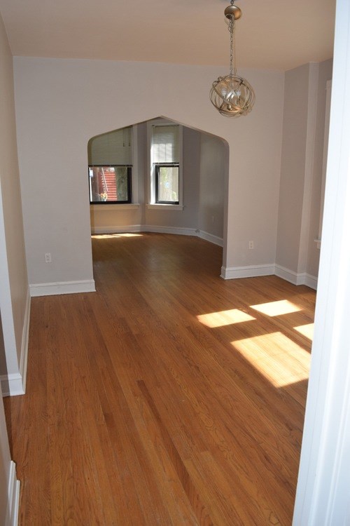 A room with wooden floors and a chandelier.