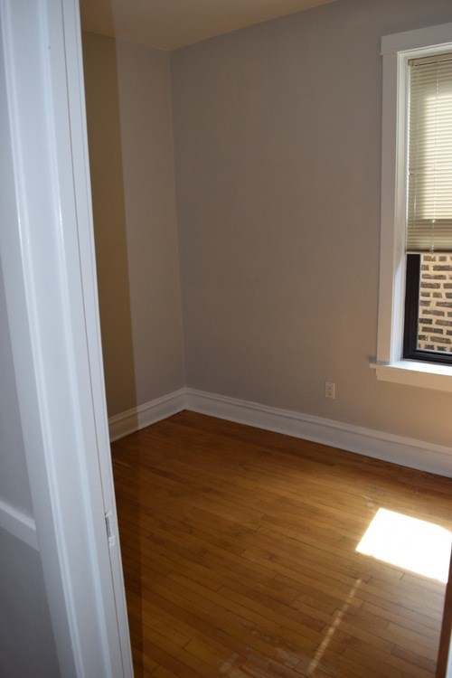 A room with a window and wooden floors.