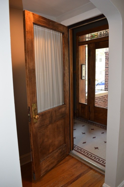 A wooden door with a glass window and a handle.