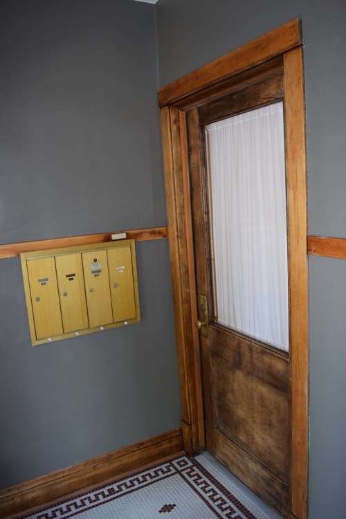 A wooden door with a white curtain on the other side.