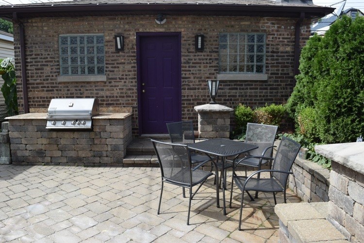 A patio with a table and chairs outside a house.