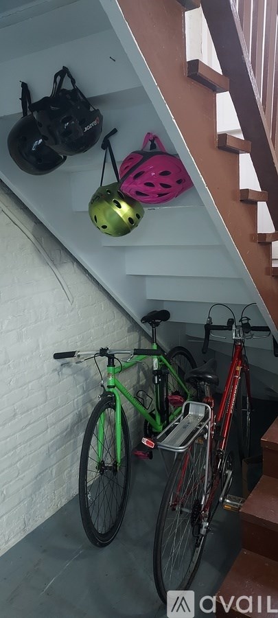 Two bikes are parked under a staircase.
