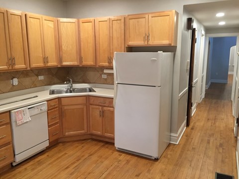 A kitchen with wooden cabinets and a white refrigerator.
