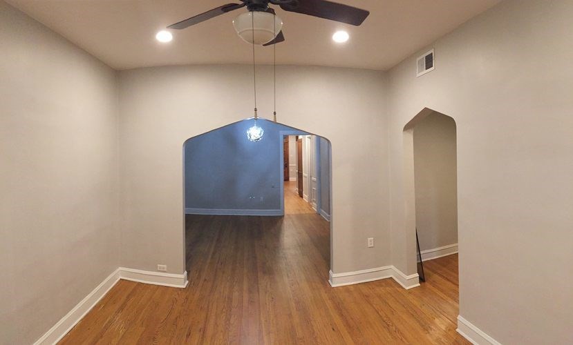 A room with a blue ceiling fan.