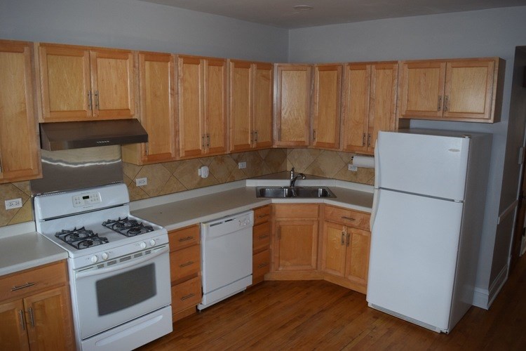 A kitchen with wooden cabinets and a white refrigerator.