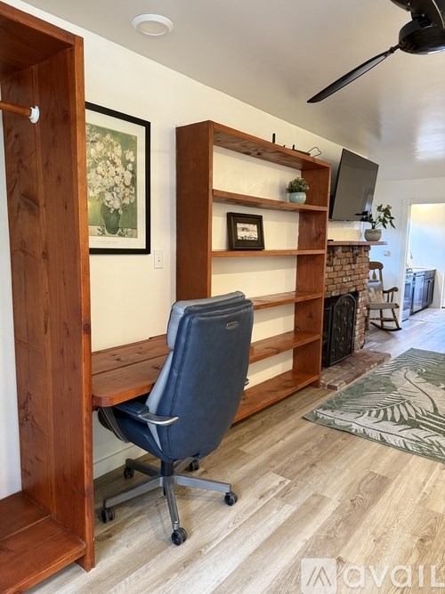 A room with a blue chair and a wooden shelf.