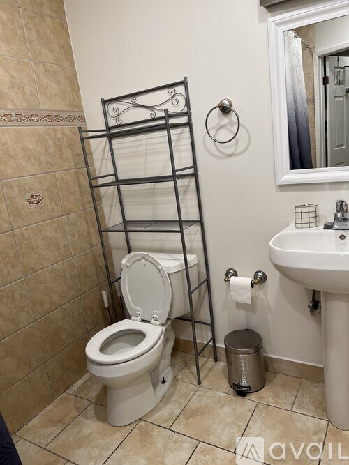 A bathroom with a toilet, sink, and towel rack.