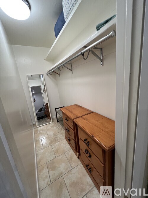 A small room with a bed and a wooden chest of drawers.