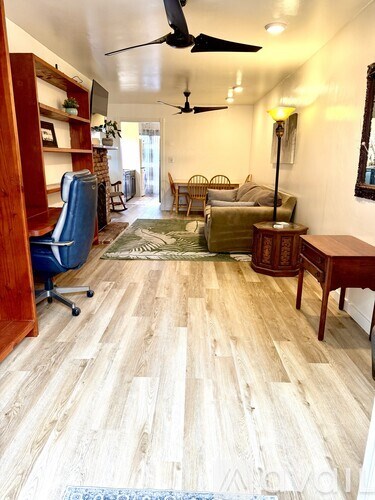 A living room with a blue chair and a brown table.