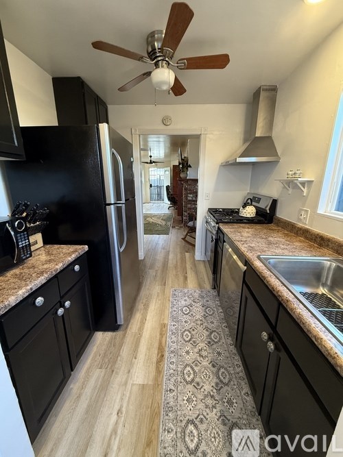 A kitchen with black cabinets and a granite countertop.