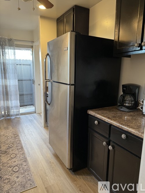 A kitchen with a refrigerator and a counter.