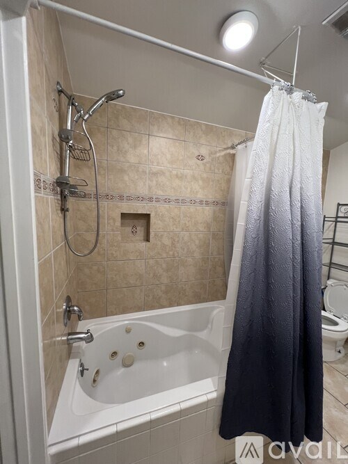 A bathroom with a white tub and a shower curtain.