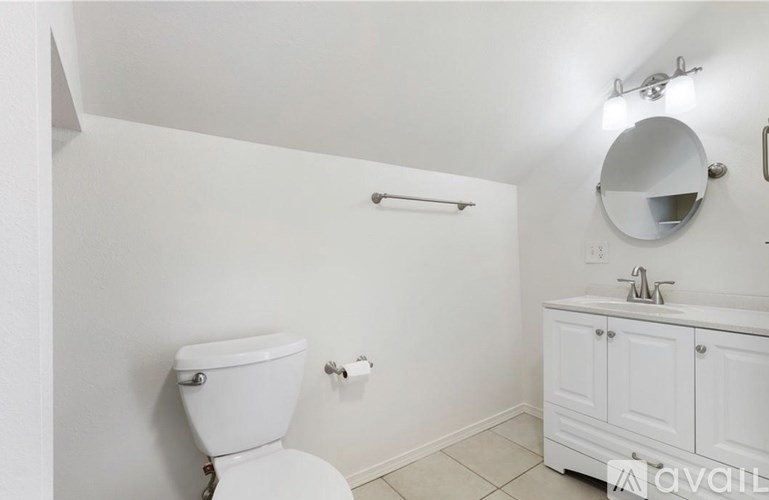 A white toilet with a white sink and a white cabinet.
