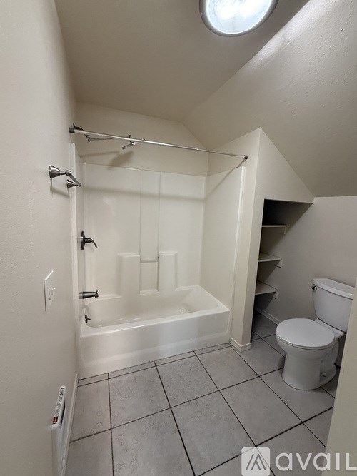 A bathroom with a toilet, tub, and shower.