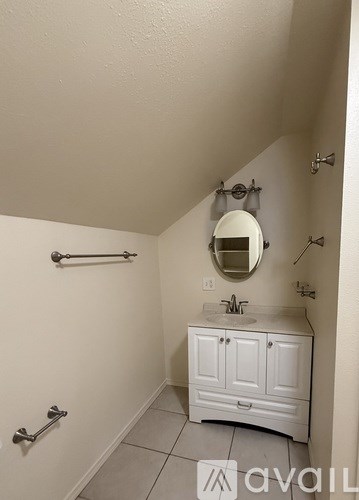 A white bathroom with a sink and a mirror.