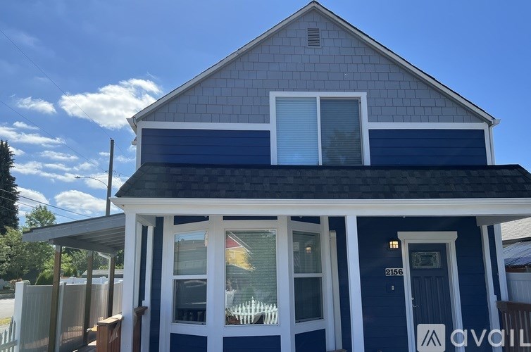A house with a blue front and white trim is for sale.