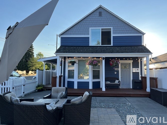A house with a blue exterior and a white picket fence.
