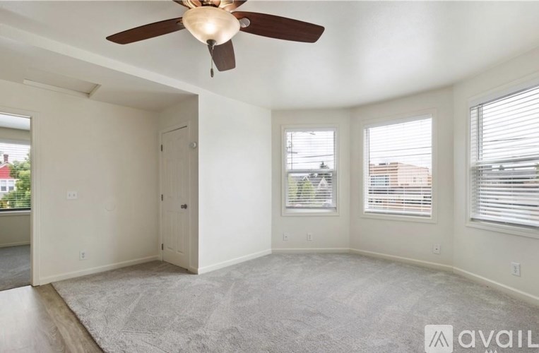 A room with a ceiling fan and carpeted floor.