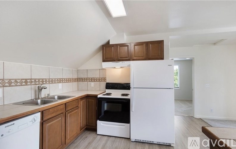 A kitchen with white appliances and wooden cabinets.