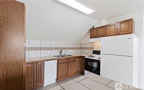 A kitchen with wooden cabinets and white appliances.