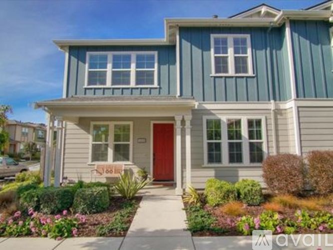 A blue house with a red door and a white porch.