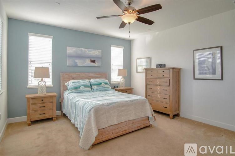 A bedroom with a bed, dresser, and ceiling fan.