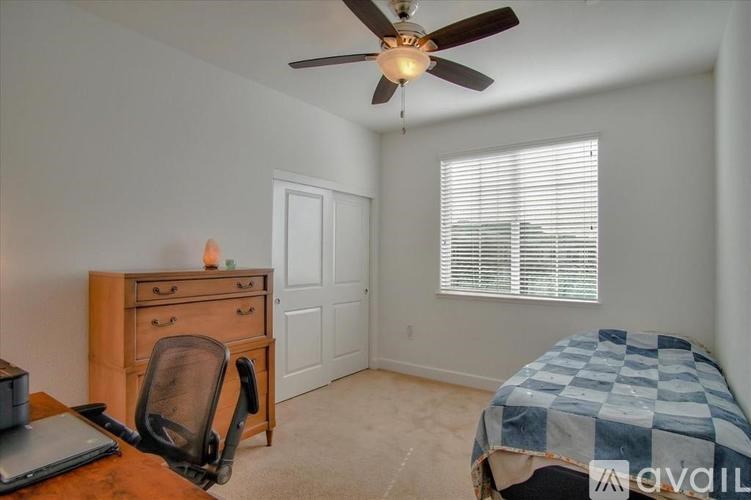 A room with a bed, chair, and a dresser.