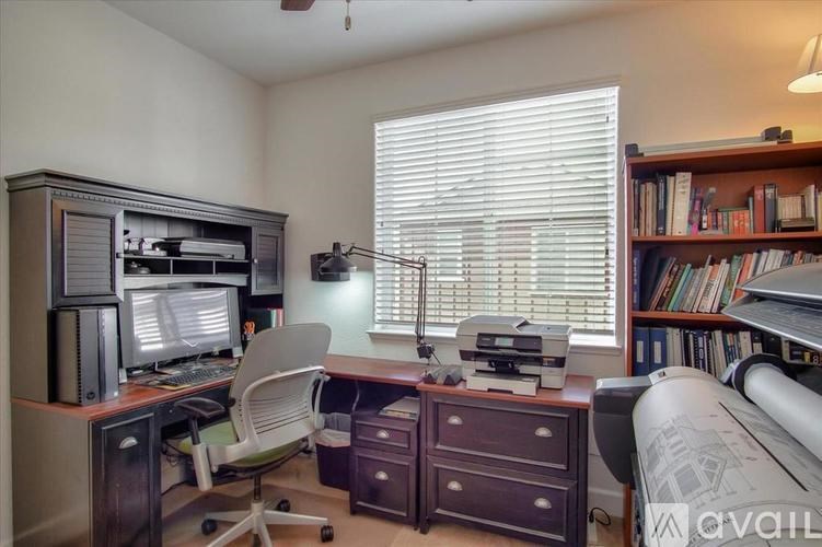 A room with a desk, chair, and bookshelf.