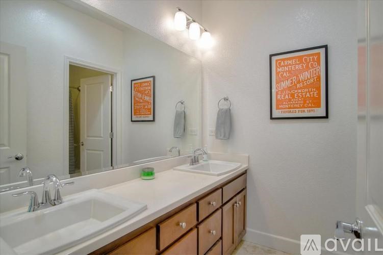 A bathroom with a poster on the wall advertising a summer resort.