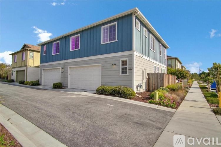 A blue and white house with a garage door is available for rent.