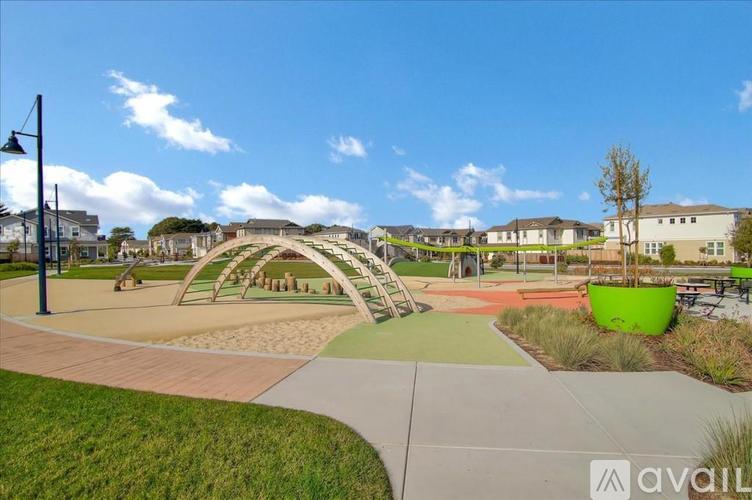 A playground with a green slide and a play structure.