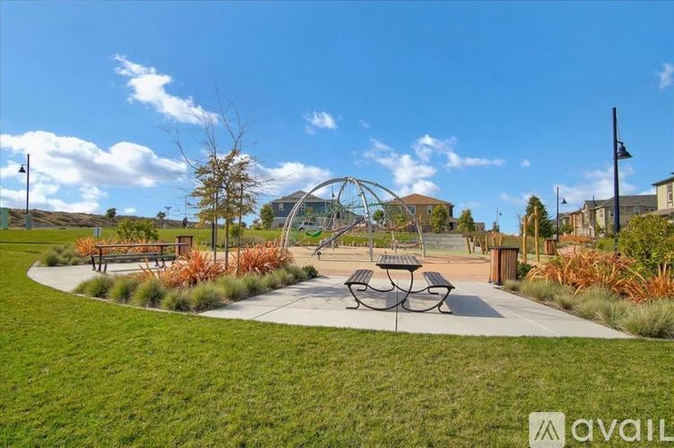 A park with a playground and a picnic table.