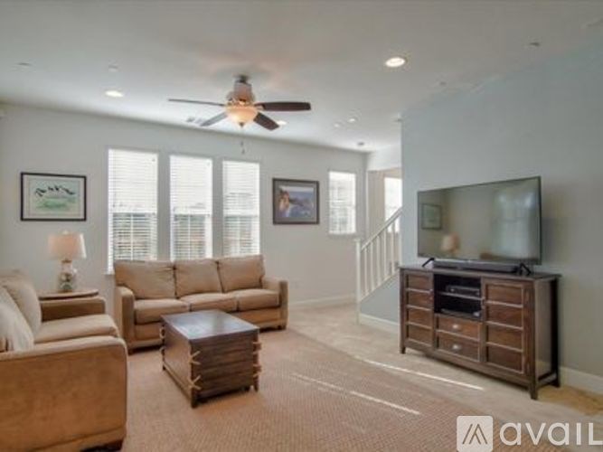 A living room with a couch, a coffee table, and a television.