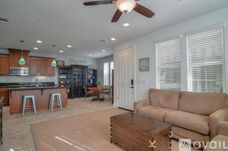 A living room with a couch, a coffee table, and a kitchen area in the background.