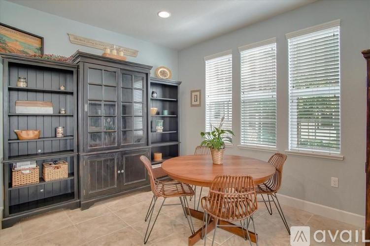 A dining room with a wooden table and chairs.